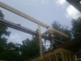 Carpenter setting a ridge beam over a new addition frame — Ice Dam Removal by Roofing Brothers in Sassamansville