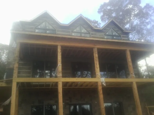 Dormers and porch framing on a large log home under construction — Roof Coating work by our crew in Sassamansville