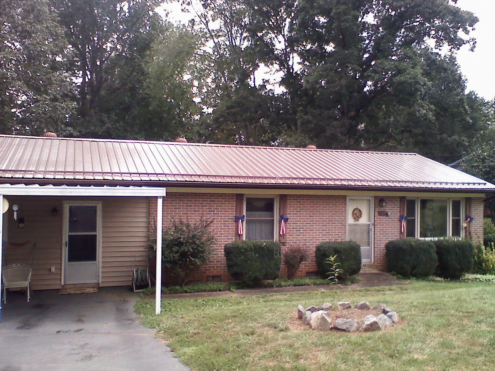 Bronze metal roof and carport on a brick ranch home — Roof Repair work by our crew in Sassamansville